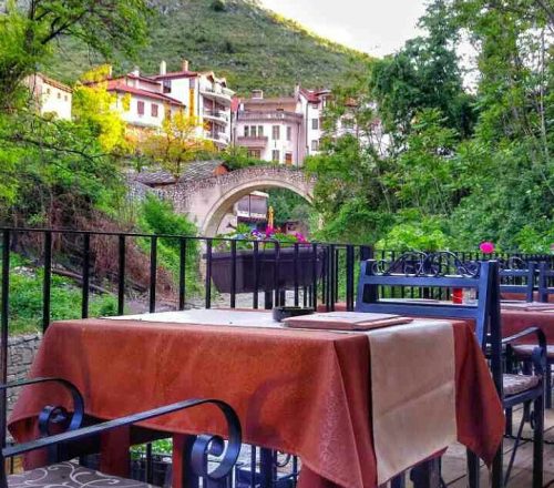 Table setting on terrace with beautiful view on the surrounding scenery with hills and trees.