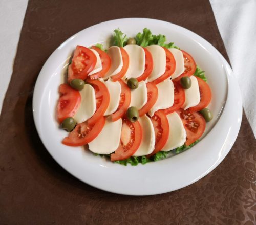 Appetizer dish with tomato and cheese.