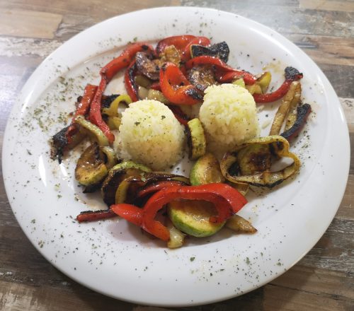 Grilled vegetables with two rice balls in the middle.