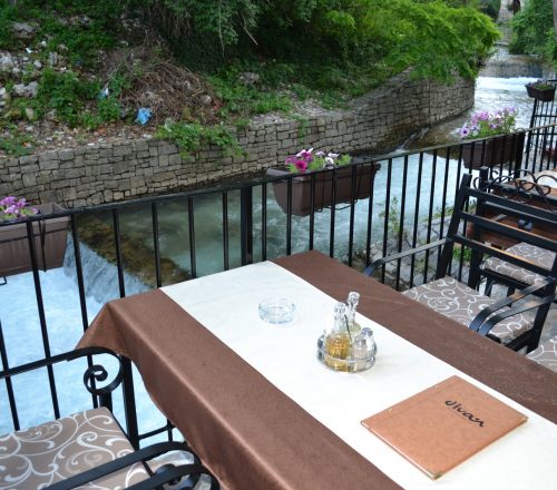 Table setting with menu placed on terrace with beautiful view on the river.