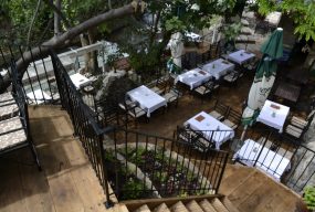 Entrance to one of three restaurant terraces with stairs leading down to outdoor seating where traditional food is enjoyed.